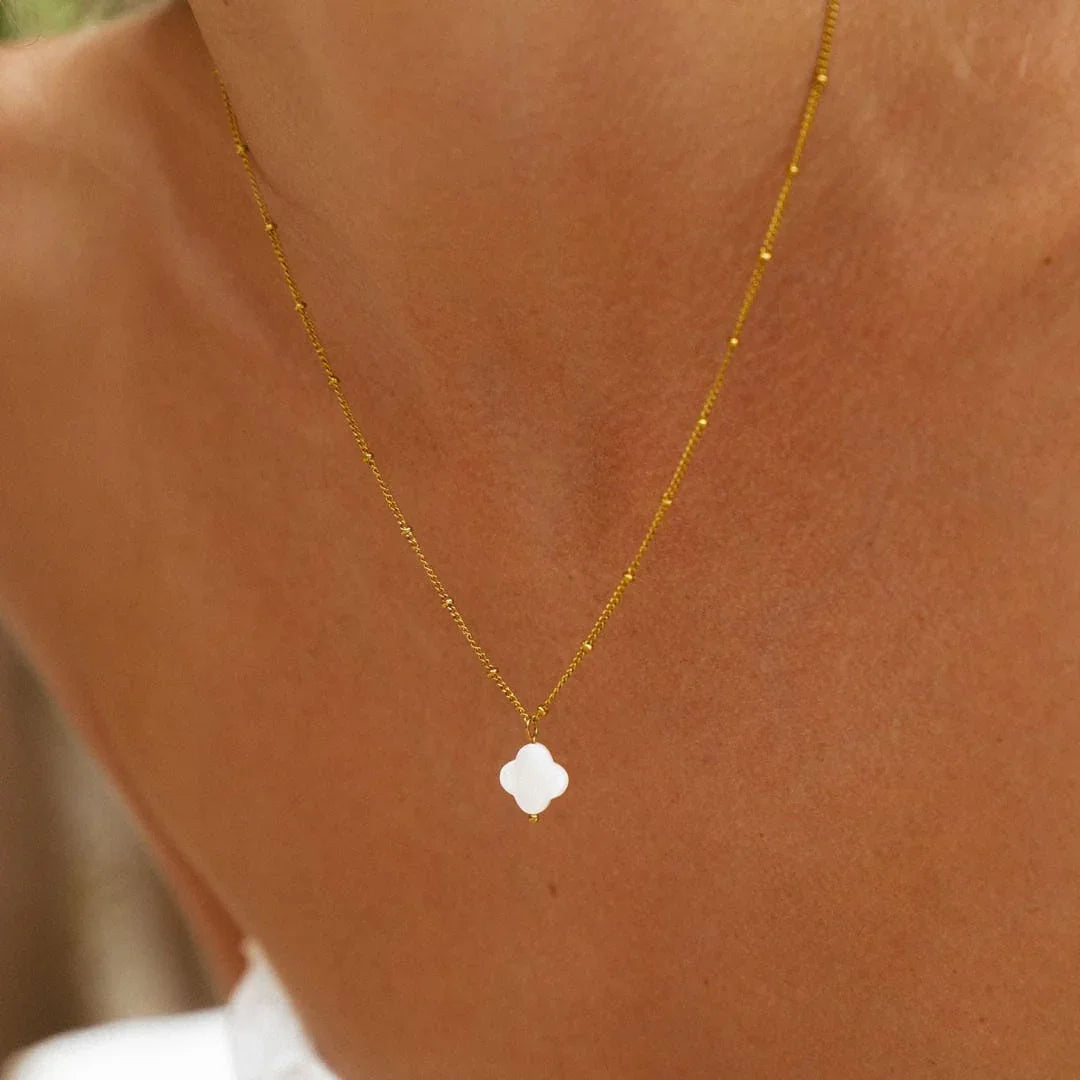 Gold pendant necklace with white clover motif